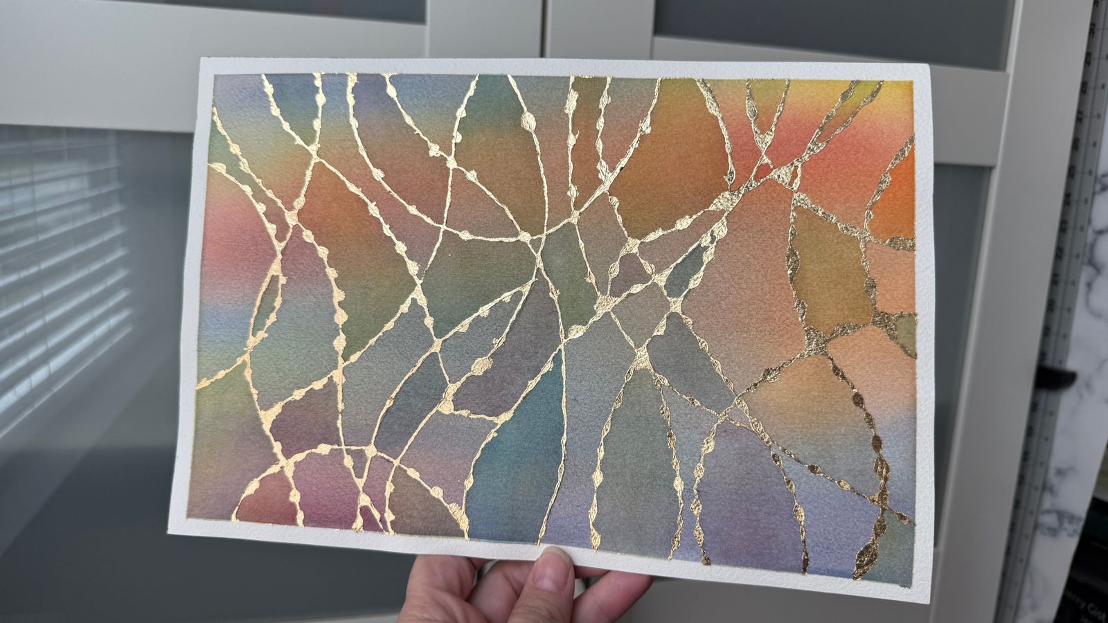 Jen's abstract watercolor with a soft rainbow wash crossed by shimmering gold lines