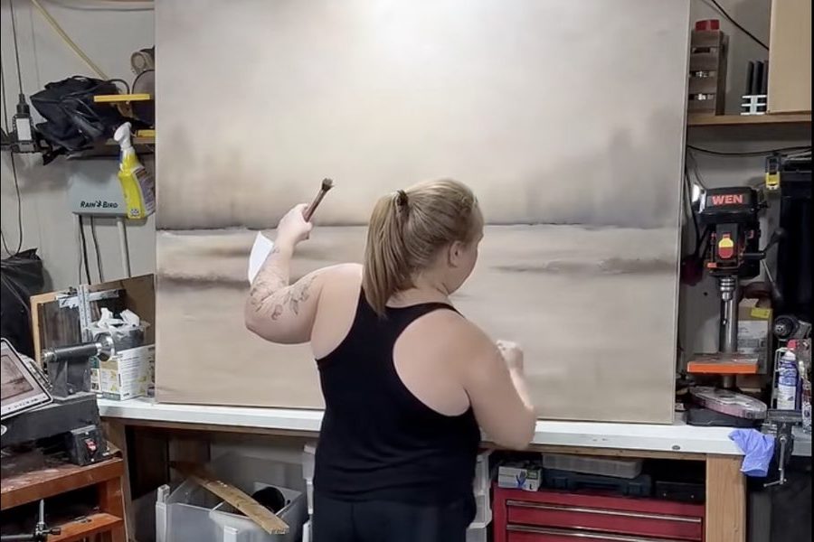 Jen painting a large misty landscape canvas in her studio