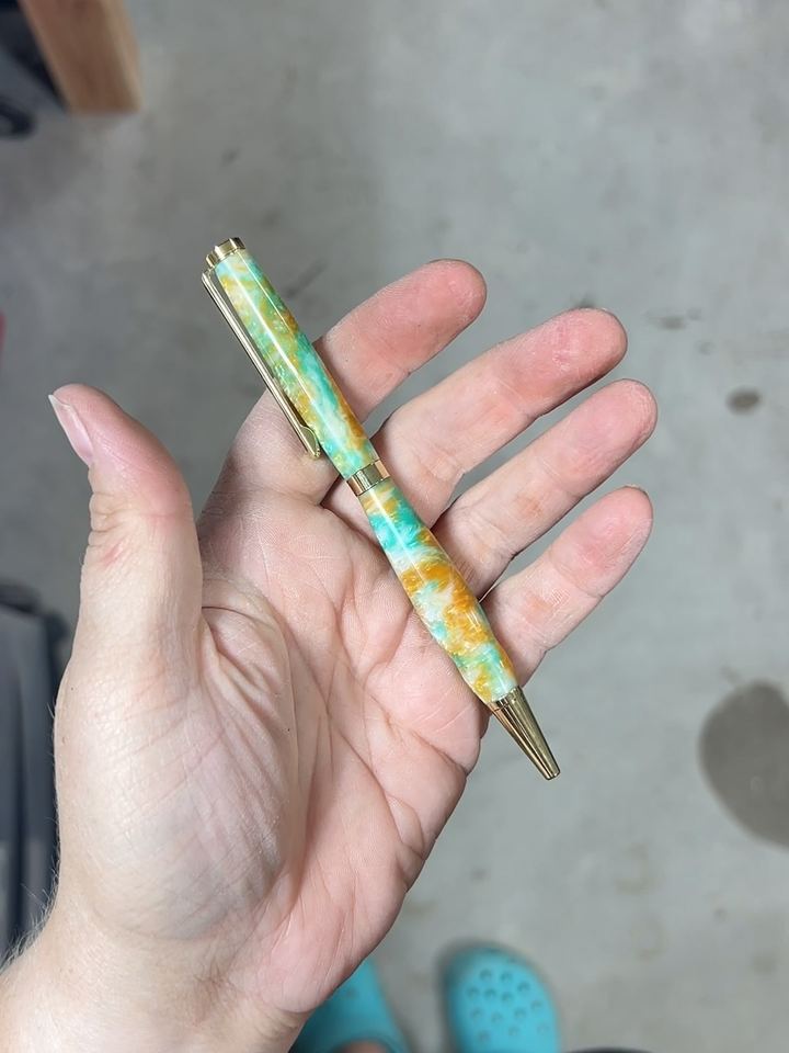 Pen with swirled teal, white, and orange resin and gold hardware
